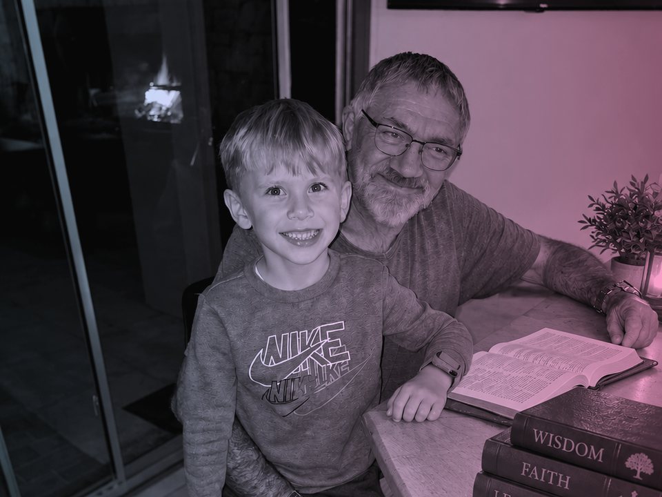 A grandfather and grandson sharing a book